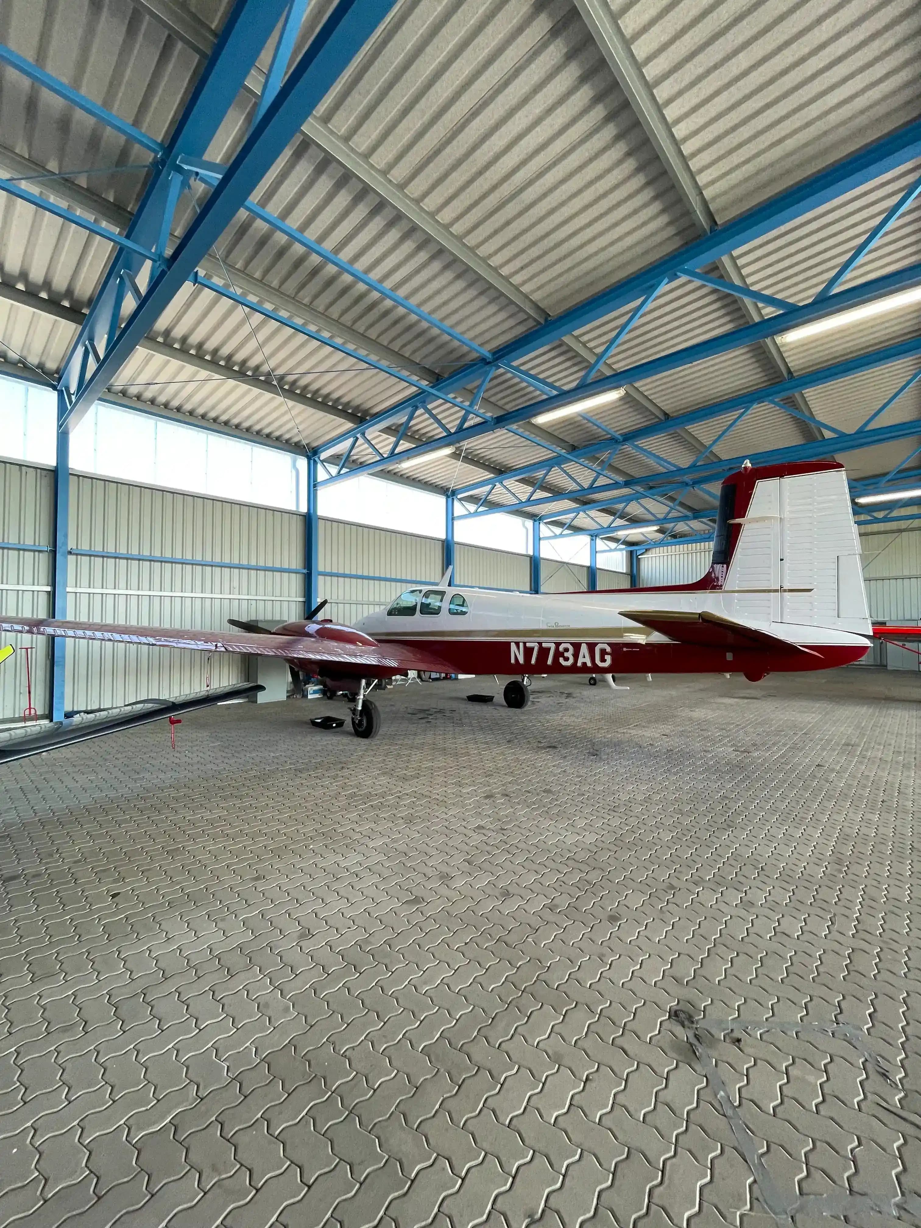 Beechcraft Twin Bonanza N773AG parked inside hangar at Magdeburg before flight to AERO