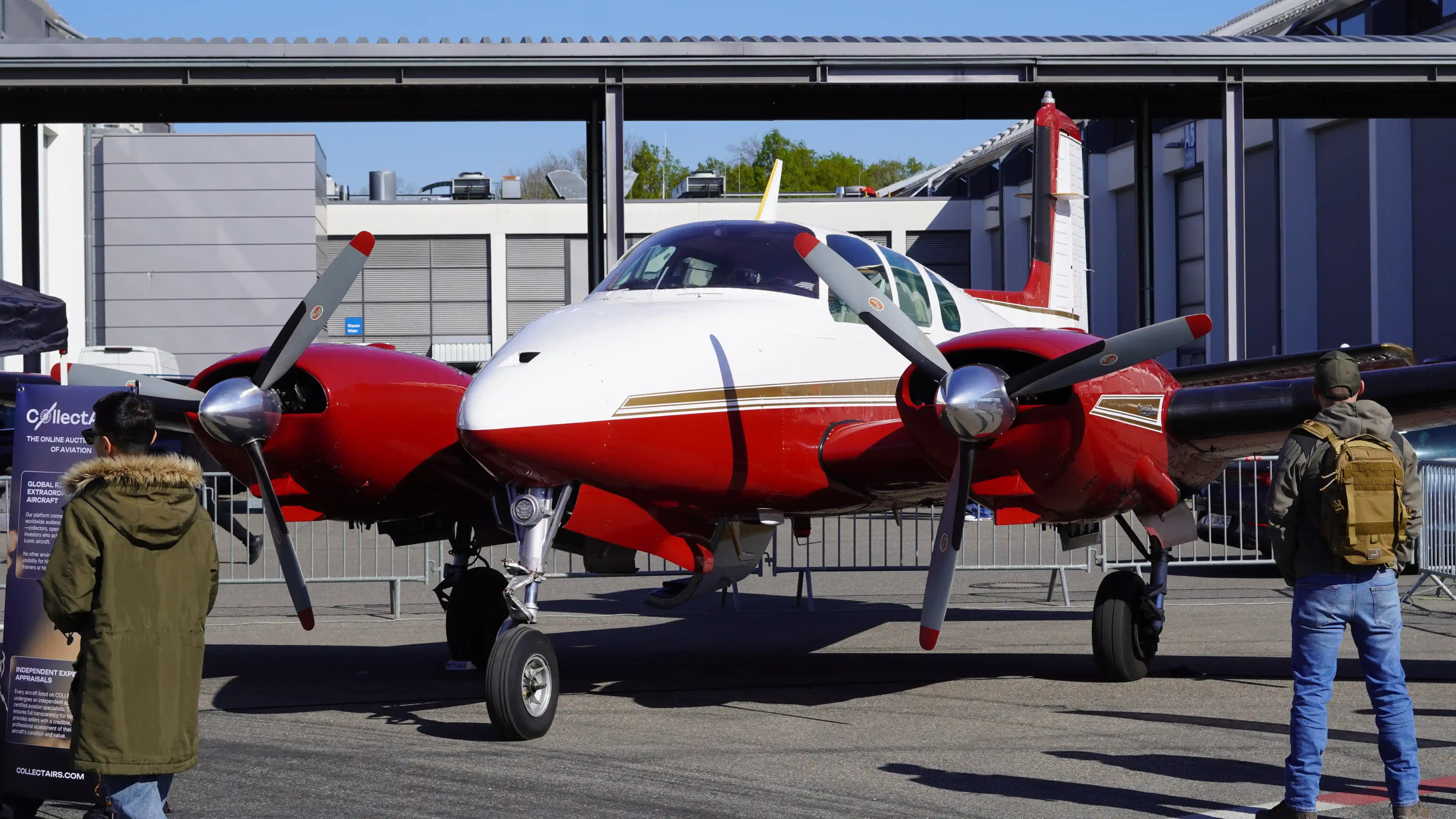 Red and white Beechcraft Twin Bonanza on display at AERO Friedrichshafen with CollectAirs branding