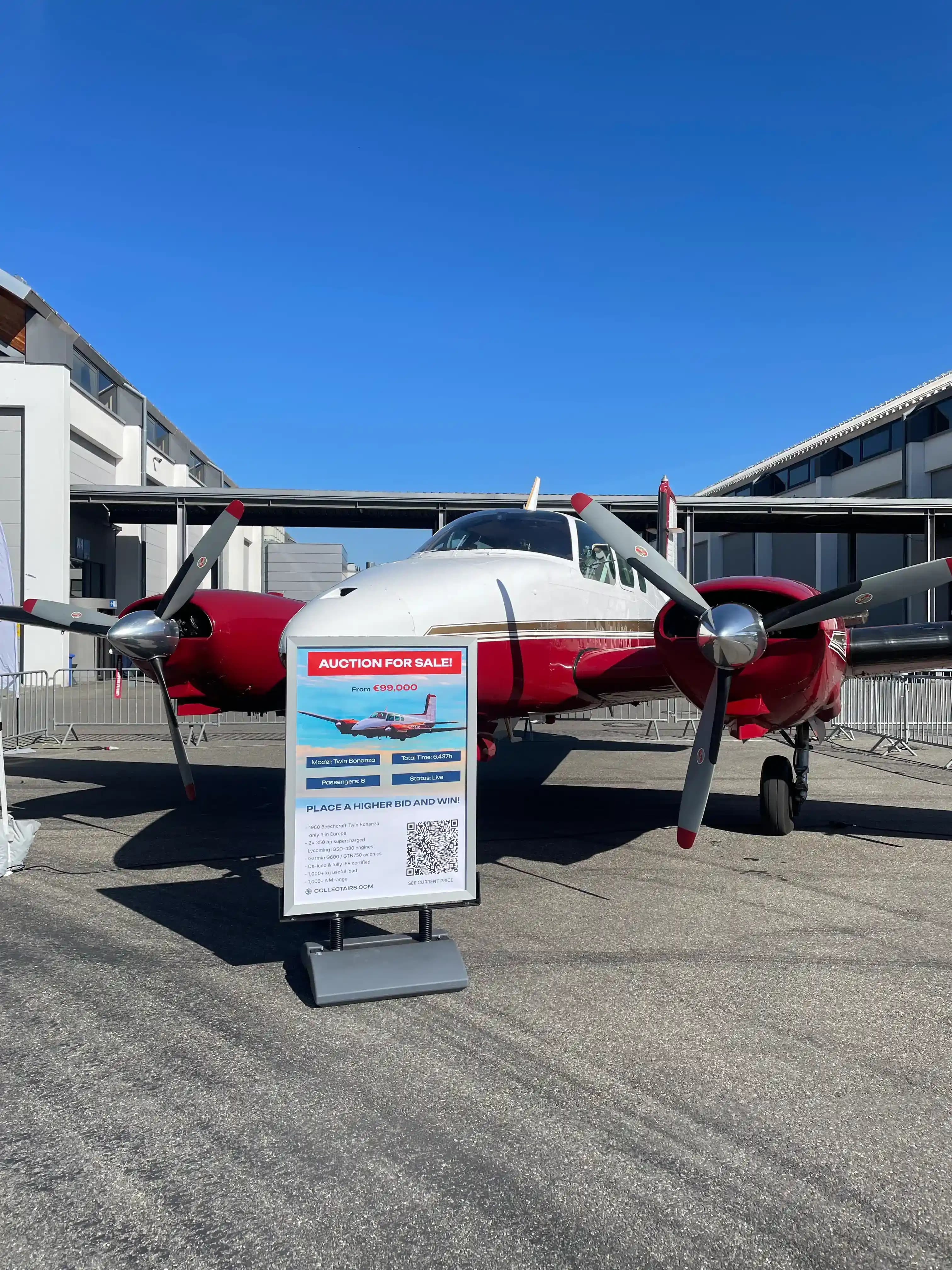 Live aircraft auction sign for Beechcraft Twin Bonanza at CollectAirs AERO 2026 display