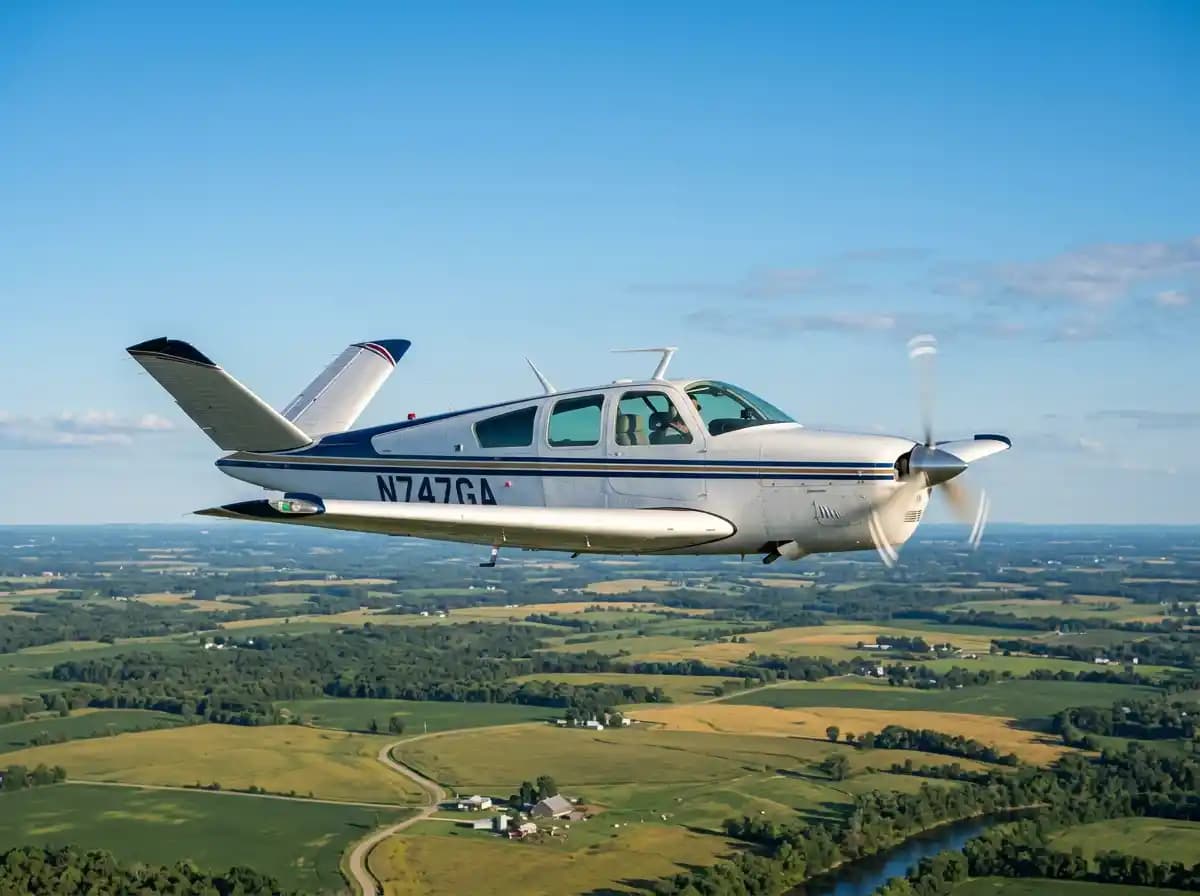 Beechcraft V-tail Bonanza in flight with ruddervator V-tail surfaces clearly visible against blue sky